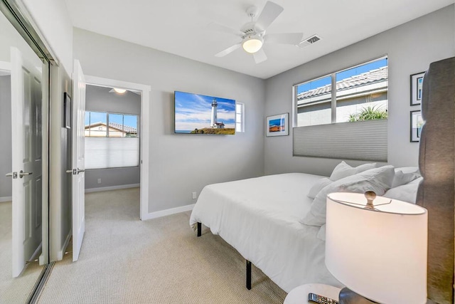 carpeted bedroom with ceiling fan and multiple windows