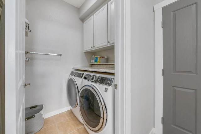 washroom featuring cabinets, light tile patterned floors, and washer and dryer