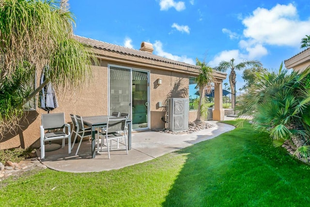 rear view of house with a patio and a yard