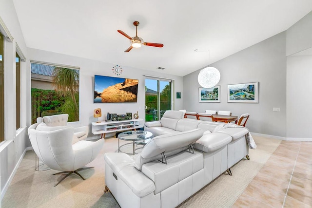 living room featuring ceiling fan, light tile patterned floors, and lofted ceiling