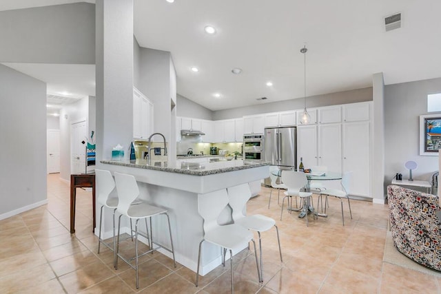 kitchen featuring light stone countertops, decorative light fixtures, white cabinetry, stainless steel appliances, and kitchen peninsula