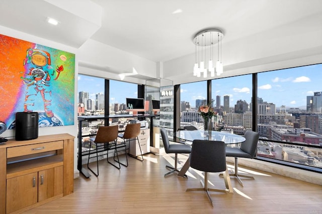 dining area with plenty of natural light, a notable chandelier, and light wood-type flooring