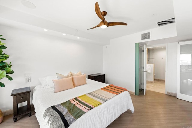 bedroom featuring ceiling fan, ensuite bathroom, and hardwood / wood-style floors