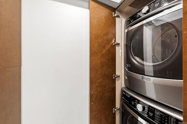 washroom with stacked washer and dryer and laundry area