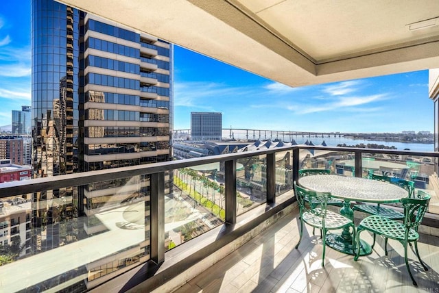 balcony featuring a view of city and a water view