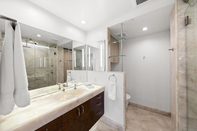 bathroom featuring toilet, vanity, visible vents, baseboards, and a marble finish shower