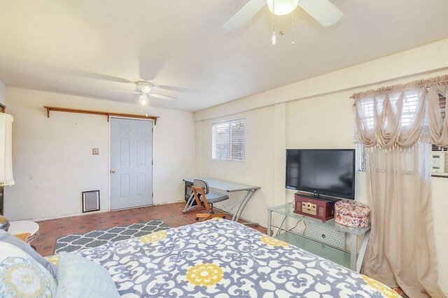 bedroom with ceiling fan and a barn door