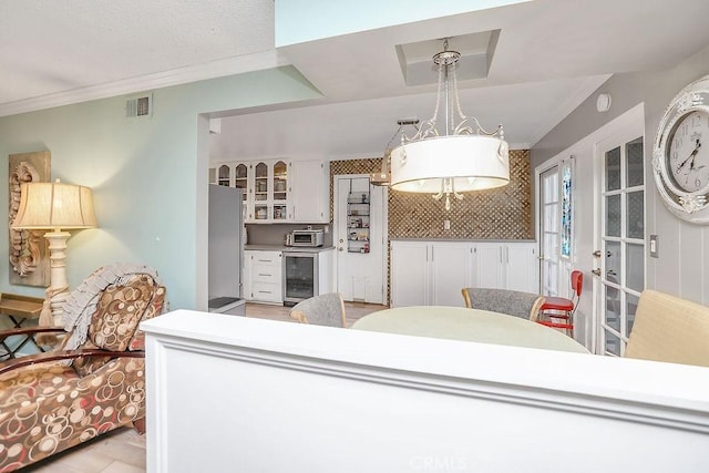 interior space with ornamental molding and beverage cooler