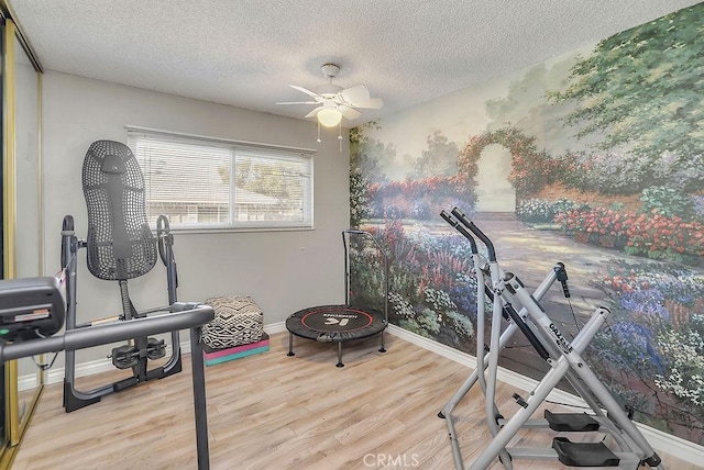 exercise area with a textured ceiling, ceiling fan, and light hardwood / wood-style flooring