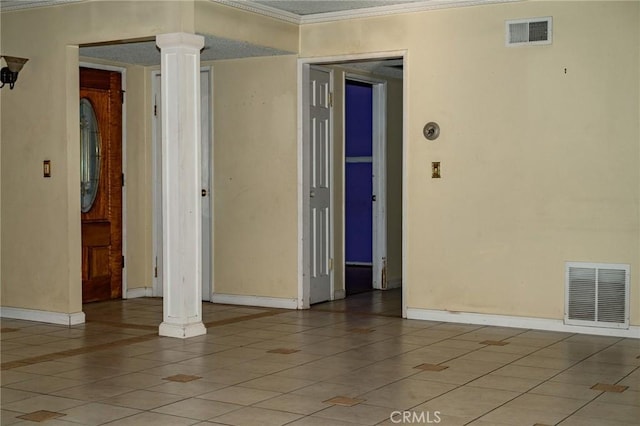 unfurnished room featuring light tile patterned floors, ornamental molding, and ornate columns