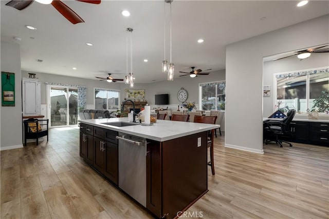 kitchen with decorative light fixtures, dishwasher, light hardwood / wood-style floors, a kitchen island with sink, and dark brown cabinets