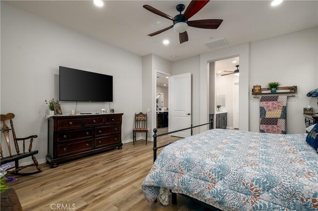 bedroom featuring ceiling fan, light hardwood / wood-style flooring, and ensuite bath