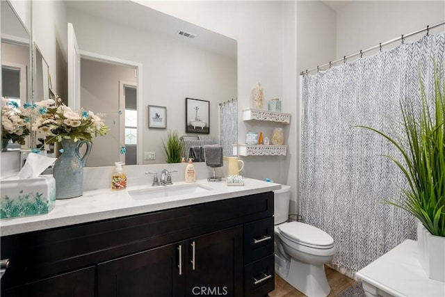 bathroom featuring toilet, wood-type flooring, and vanity