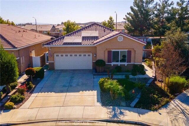 mediterranean / spanish-style home featuring a garage and solar panels