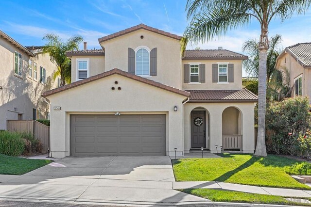 mediterranean / spanish-style house featuring a garage and a front lawn