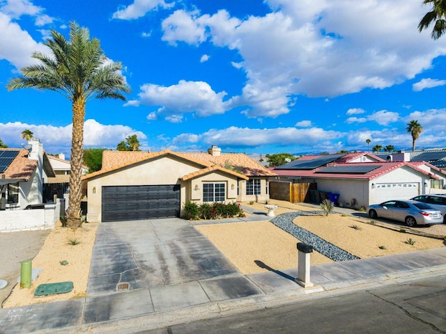 ranch-style house featuring solar panels and a garage