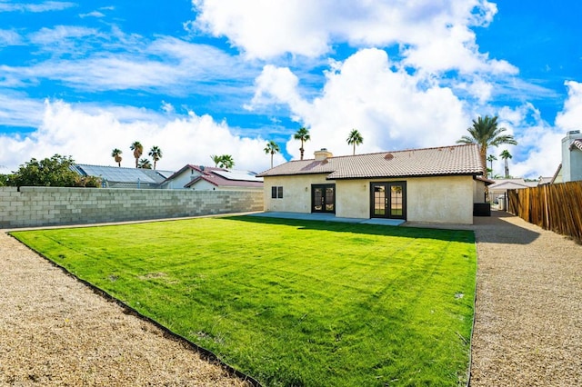 back of property featuring a yard and french doors