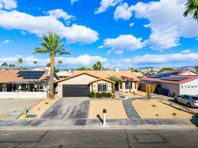 ranch-style house featuring solar panels and a garage