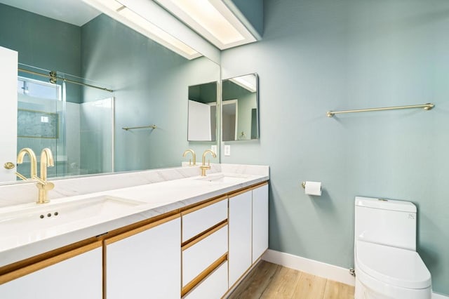 bathroom with hardwood / wood-style flooring, toilet, walk in shower, and vanity