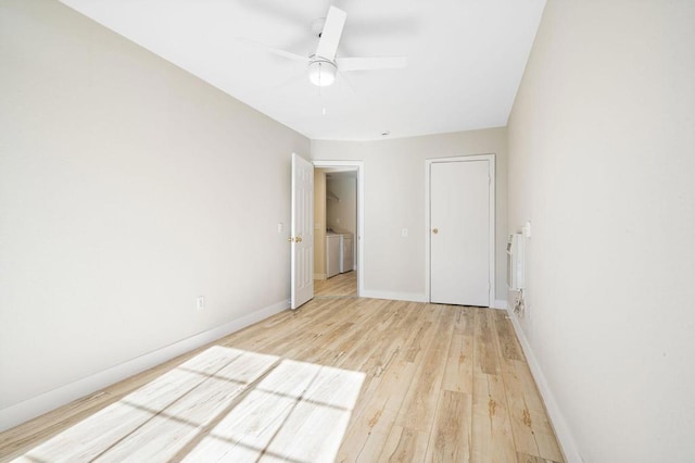 unfurnished bedroom featuring light wood-type flooring, ceiling fan, and washer and dryer