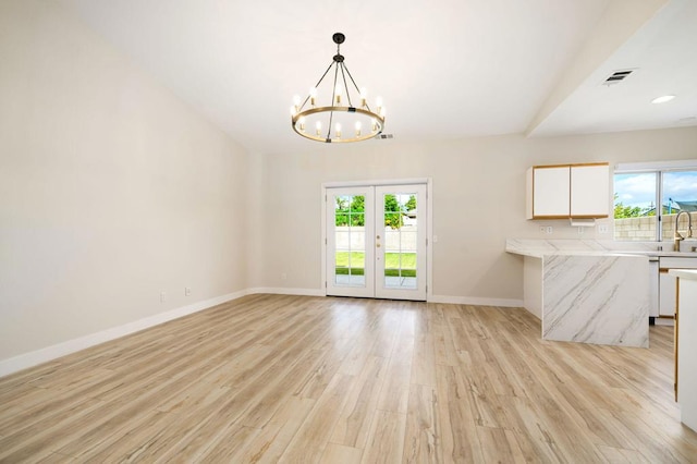 interior space featuring french doors, a chandelier, and light hardwood / wood-style flooring