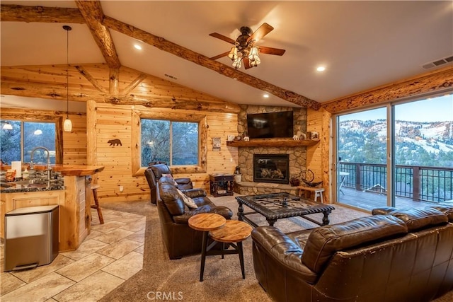 living room featuring ceiling fan, sink, wood walls, and lofted ceiling with beams