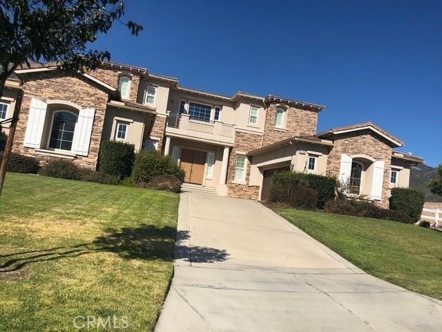 11090 Hiddentrail Dr, Rancho Cucamonga, CA 91737 - view of front of house with a garage, a front lawn, and a balcony