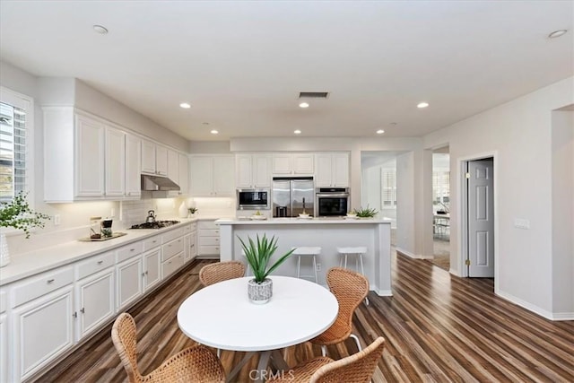 kitchen featuring white cabinets, stainless steel appliances, and a kitchen island