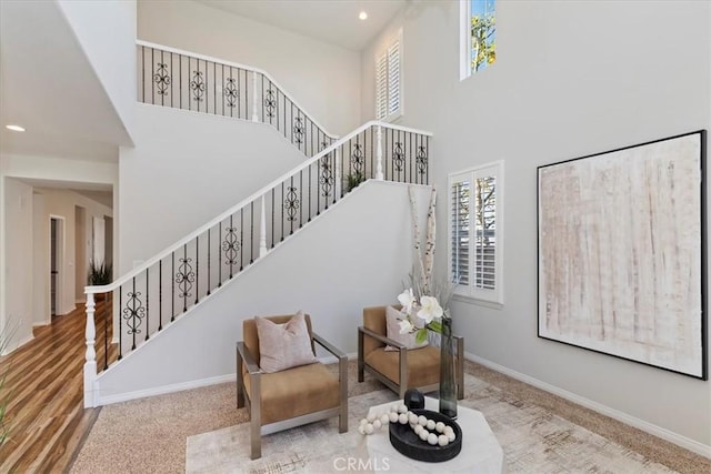 staircase featuring a towering ceiling and carpet floors