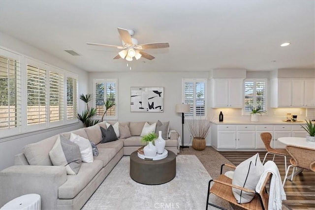 living room with ceiling fan and light hardwood / wood-style flooring