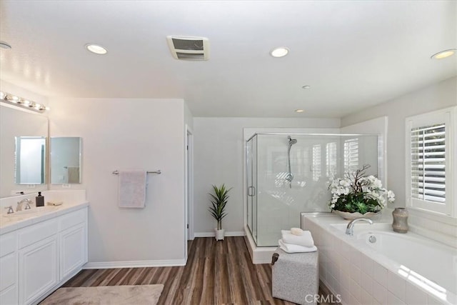 bathroom featuring hardwood / wood-style flooring, separate shower and tub, and vanity