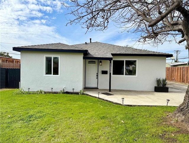 back of property with a patio and a yard