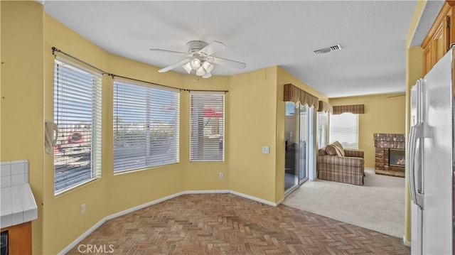 interior space featuring ceiling fan and a brick fireplace