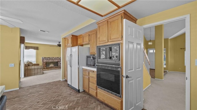 kitchen with ceiling fan, a fireplace, and black appliances