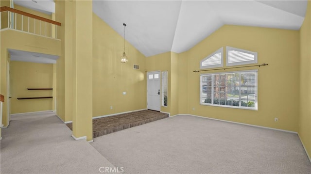 carpeted foyer entrance featuring high vaulted ceiling and a notable chandelier