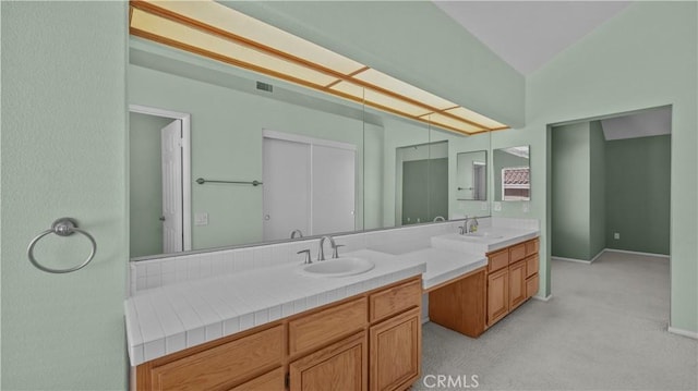 bathroom with vanity and vaulted ceiling