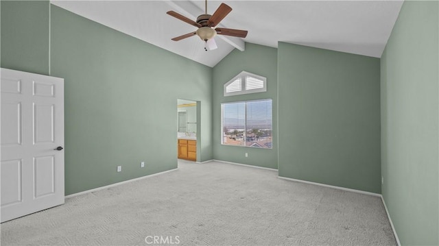 carpeted spare room with ceiling fan and high vaulted ceiling