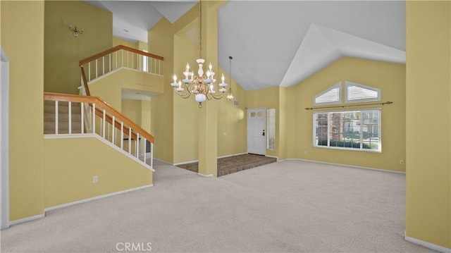 entrance foyer featuring high vaulted ceiling, a notable chandelier, and carpet flooring