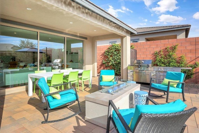 view of patio featuring a grill, an outdoor kitchen, and a fire pit