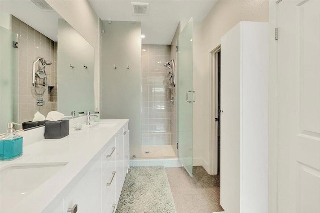 bathroom featuring tile patterned flooring, a shower with shower door, and vanity