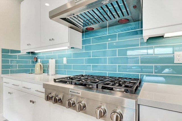 kitchen featuring exhaust hood, decorative backsplash, and white cabinetry