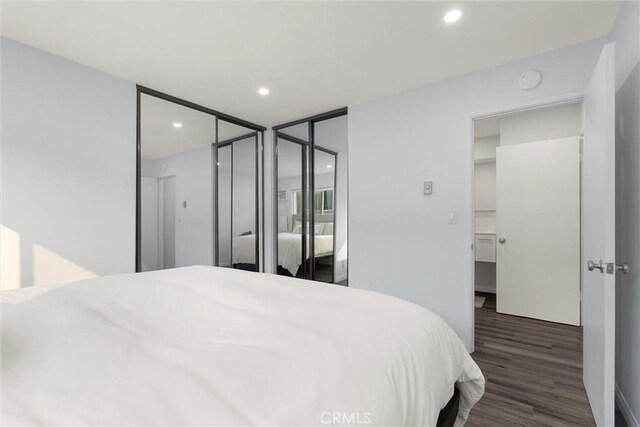 bedroom with dark wood-type flooring and a closet