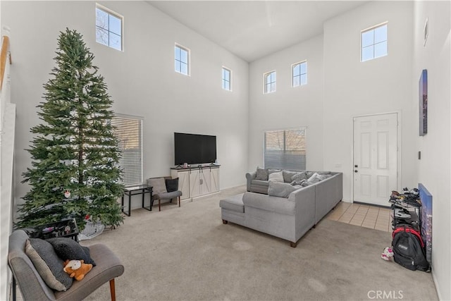 carpeted living room featuring a wealth of natural light and a towering ceiling