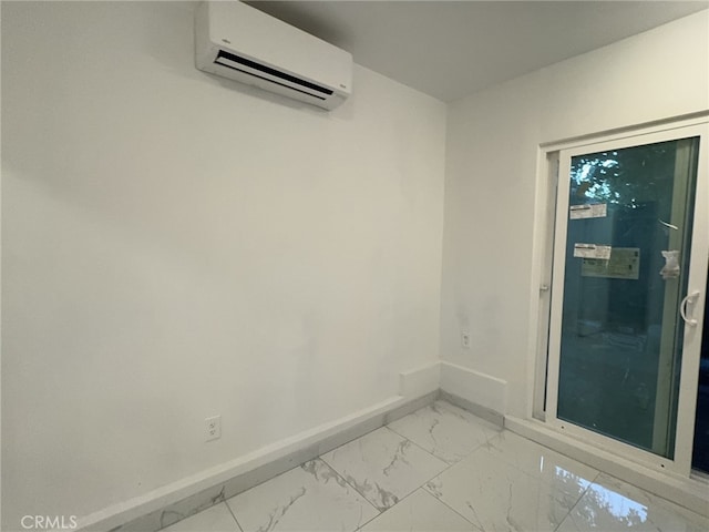 unfurnished room with marble finish floor, baseboards, and a wall mounted AC