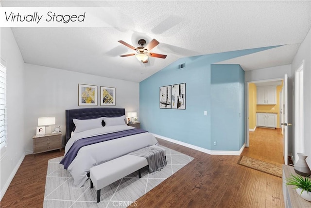 bedroom featuring ceiling fan, vaulted ceiling, a textured ceiling, and hardwood / wood-style flooring