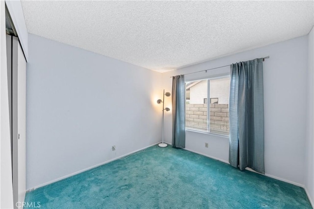 carpeted spare room featuring a textured ceiling