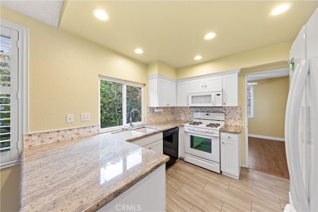 kitchen with light stone counters, white appliances, and white cabinetry