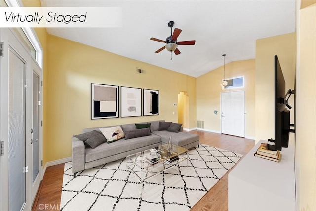 living room with ceiling fan, hardwood / wood-style floors, and vaulted ceiling