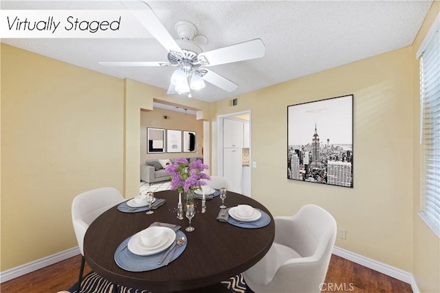 dining space featuring a textured ceiling, ceiling fan, and dark hardwood / wood-style flooring