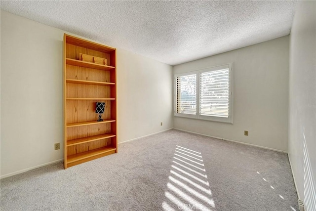 carpeted spare room featuring built in features and a textured ceiling